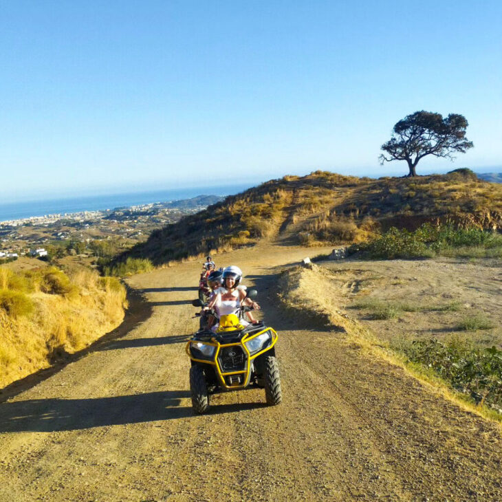 yellow-quad-enhanced girls driving wuads with a sea behind them